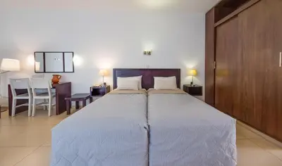 a bedroom with a large bed and a table at MarisMare Apartments in Ayia Napa