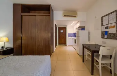 a bedroom with a bed and a table and a refrigerator at MarisMare Apartments in Ayia Napa