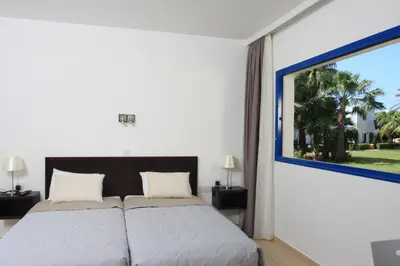 a bedroom with a bed and a large window at MarisMare Apartments in Ayia Napa