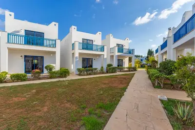 a row of white apartment buildings with a yard at MarisMare Apartments in Ayia Napa