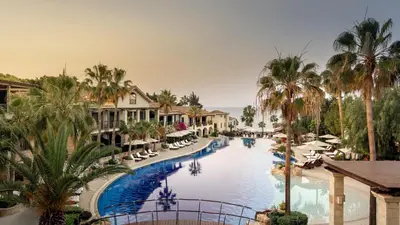 a view of a pool at a resort with palm trees at Columbia Beach Resort in Pissouri