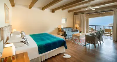 a bedroom with a bed and a living room at Columbia Beach Resort in Pissouri