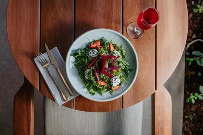 a plate of salad on a table with a glass at Napa Plaza Hotel (Adults Only) in Ayia Napa