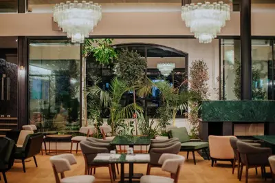 a restaurant with tables and chairs and chandeliers at Napa Plaza Hotel (Adults Only) in Ayia Napa