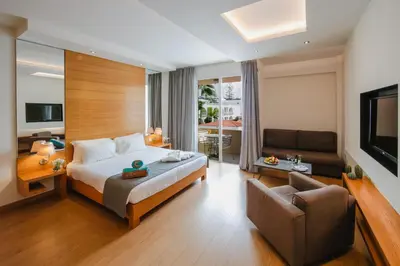 a bedroom with a bed and a couch and a television at Napa Plaza Hotel (Adults Only) in Ayia Napa