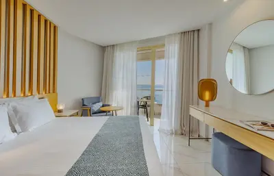 a hotel room with a bed and a view of the ocean at Golden Bay Beach Hotel in Larnaka