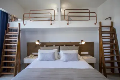 a bedroom with a bed with two bunk beds at Lordos Beach Hotel & Spa in Larnaka