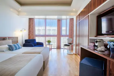 a hotel room with a bed and a tv at Lordos Beach Hotel & Spa in Larnaka