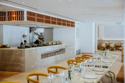 a restaurant with two chefs preparing food in a kitchen at Lordos Beach Hotel & Spa in Larnaka