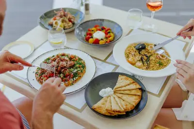 a group of people sitting around a table eating food at Lordos Beach Hotel & Spa in Larnaka