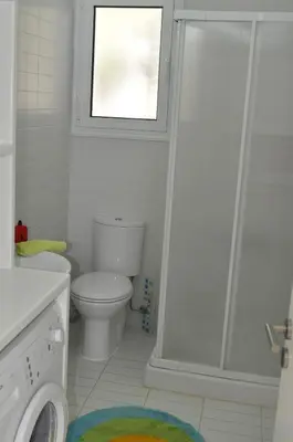 a bathroom with a toilet and a shower with a window at Katikies 22 in Pissouri