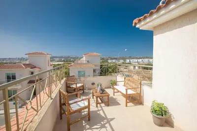 a balcony with chairs and a table on a house at George's Lux Villa in Protaras