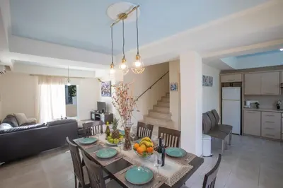a dining room and living room with a table and chairs at George's Lux Villa in Protaras