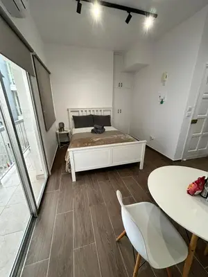 a bedroom with a bed and a table with chairs at Harmony Studios in Larnaka