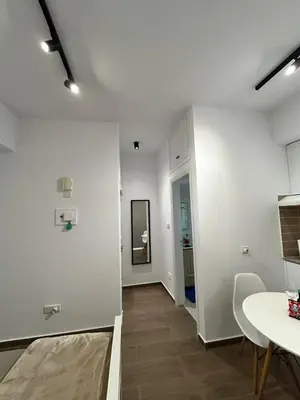 a living room with a table and a white wall at Harmony Studios in Larnaka