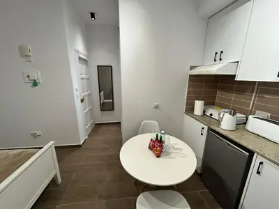 a small kitchen with a white table and a counter at Harmony Studios in Larnaka