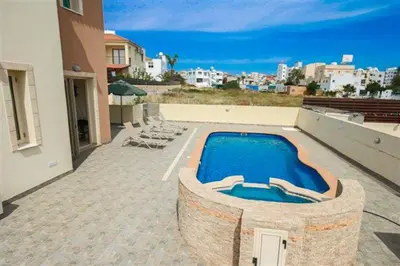 a swimming pool on the side of a house at Villa Florie in Protaras