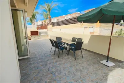 a table and chairs with an umbrella on a patio at Villa Florie in Protaras