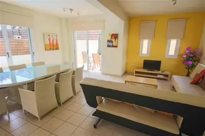 a living room with a dining room table with chairs at Villa Florie in Protaras