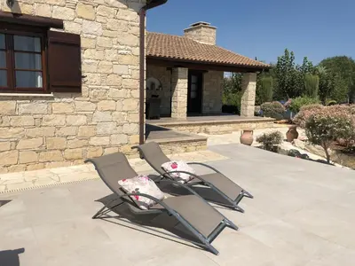 two chairs sitting on a patio in front of a house at Paradise Traditional House in Maroni