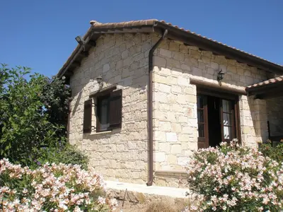 a small stone house with flowers in front of it at Paradise Traditional House in Maroni
