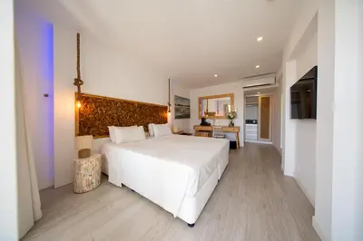 a bedroom with a large white bed and a table at Blue Harbour Boutique in Ayia Napa