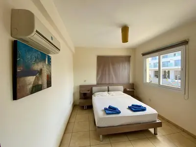 a bedroom with a bed with blue towels on it at Sunny Cyprus in Paralimni