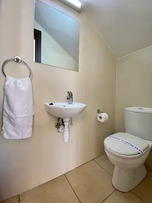 a bathroom with a toilet and a sink and a mirror at Sunny Cyprus in Paralimni