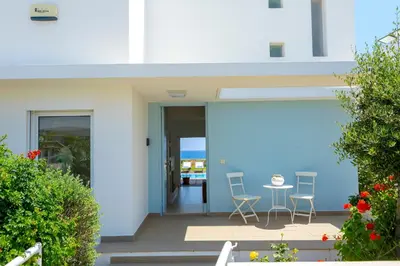 a balcony of a house with chairs and a table at Protaras Beachfront Villa Alia in Protaras