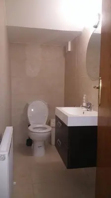a bathroom with a white toilet and a sink at Alkinoou Residence in Limassol