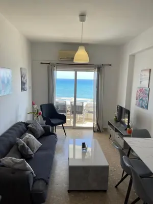 a living room with a couch and a view of the ocean at Alex Beach Apartment 51 in Larnaka