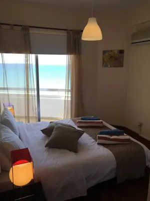 a bedroom with a large bed with a view of the ocean at Alex Beach Apartment 51 in Larnaka