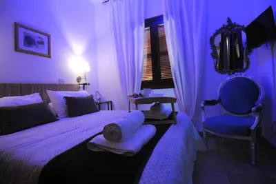 a purple bedroom with a bed and a chair at La C Mer in Larnaka