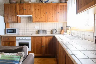 a kitchen with wooden cabinets and a counter top at Vasiliou House in Khandria