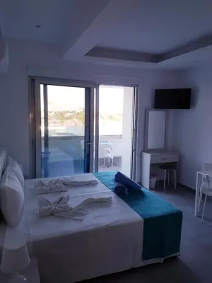 a bedroom with a large bed and a large window at Christopher's Sandy Beach Suites in Ayia Napa