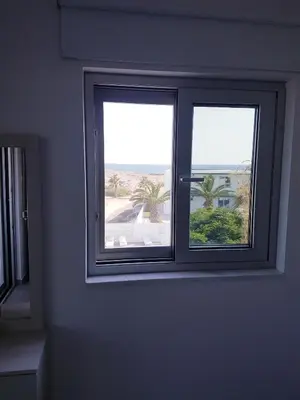 two windows in a room with a view of the beach at Christopher's Sandy Beach Suites in Ayia Napa