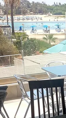 a view of a beach from a table and chairs at Christopher's Sandy Beach Suites in Ayia Napa