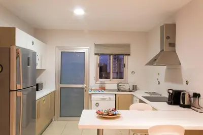 a kitchen with a table and a refrigerator at Eden Beach Apartment 207 in Limassol