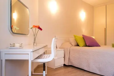 a bedroom with a bed and a desk and a mirror at Eden Beach Apartment 207 in Limassol