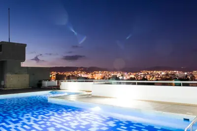 a swimming pool on the roof of a building at night at Eden Beach Apartment 207 in Limassol