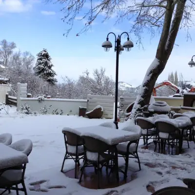 a group of tables and chairs covered in snow at Aristotelio Boutique Hotel in Pedoulas