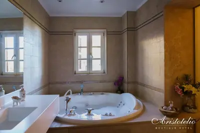 a large bathroom with a tub and a window at Aristotelio Boutique Hotel in Pedoulas