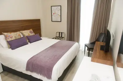 a hotel room with a bed and a tv at Manolia City Residences in Nicosia