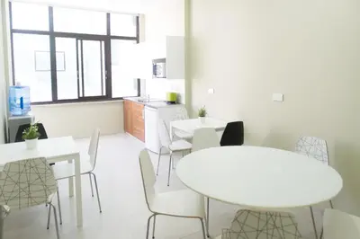 a dining room with white tables and chairs at Manolia City Residences in Nicosia