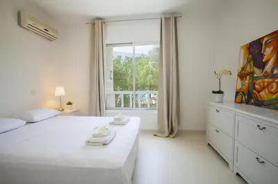 a bedroom with a large white bed and a window at Protaras Central Sunrise in Protaras