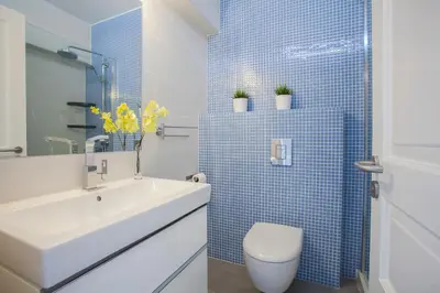 a bathroom with a sink and a toilet and blue tiles at Protaras Central Sunrise in Protaras