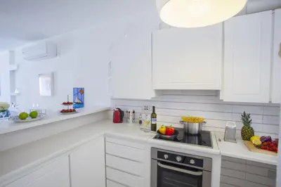 a kitchen with white cabinets and a stove top oven at Protaras Central Sunrise in Protaras