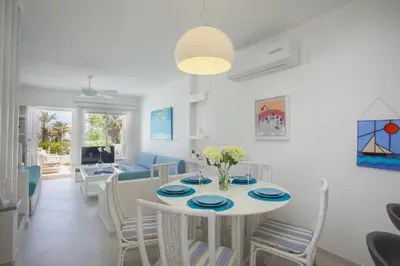 a dining room and living room with a table and chairs at Protaras Central Sunrise in Protaras