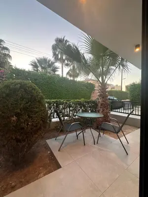 a patio with a table and chairs and a palm tree at Royal Sunset Studios & Apartments in Limassol