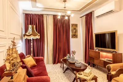 a living room with a red couch and a tv at Castle Holiday Apartments in Limassol